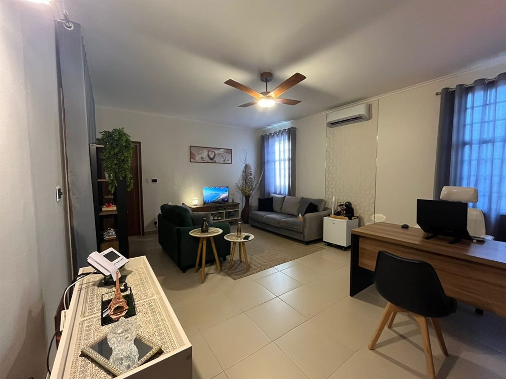 Sala de atendimento com sofá, poltrona e mesa de trabalho